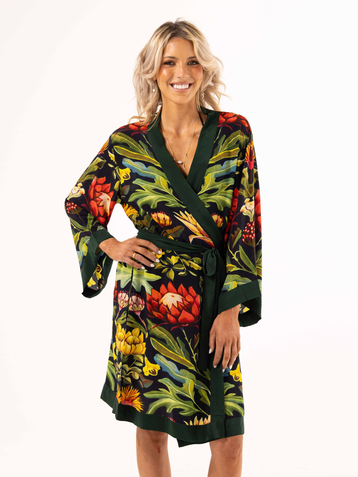 ALL•PORT silk robe in Paradisiacal Protea print by Lara Allport – front view, hand on hip, smiling, belted